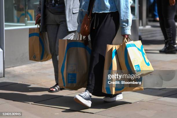 Shoppers carry bags from Primark on Market Street in Manchester, U.K., on Thursday, April 21, 2022. The Office for National Statistics are due to...