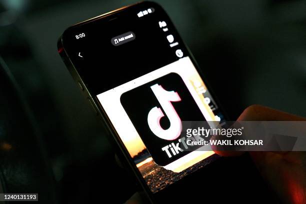 In this photo illustration taken on April 21 the icon of an video sharing mobile phone application TikTok is pictured on a mobile phone used by an...
