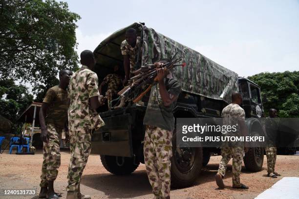 Nigerian soldiers load on a military truck on April 21, 2022 small arms and light weapons recovered from bandits during Operation Safe Haven and...