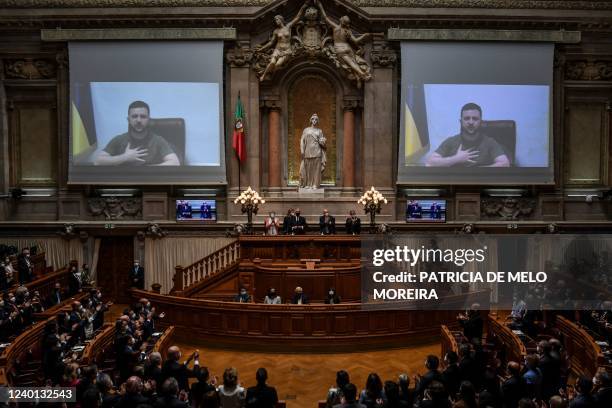 Ukrainian President Volodymyr Zelensky appears on screen to address the Portuguese Parliament by videoconference in Lisbon on April 21, 2021. - The...