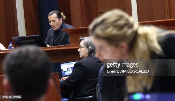 Actress Amber Heard speaks to her legal team as US actor Johhny Depp returns to the stand after a lunch recess during the 50 million US dollar Depp...