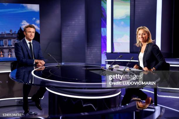 French President and La Republique en Marche party candidate for re-election Emmanuel Macron poses flanked by French journalist and TV host...