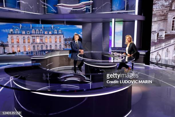 French President and La Republique en Marche party candidate for re-election Emmanuel Macron speaks with French journalist and TV host Anne-Sophie...