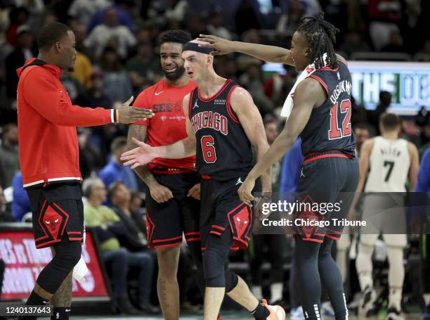 Chicago Bulls guard Alex Caruso is congratulated by his teammates late in the second half of Game Two against the Milwaukee Bucks at Fiserv Forum in...