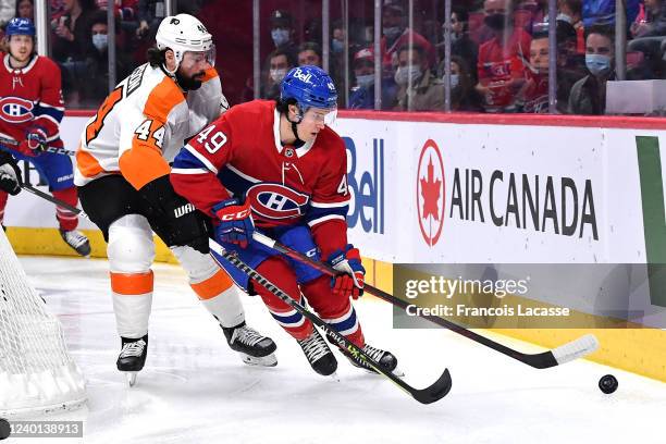 Rafael Harvey-Pinard of the Montreal Canadiens skates with the puck under pressure from Nate Thompson of the Philadelphia Flyers in the NHL game at...