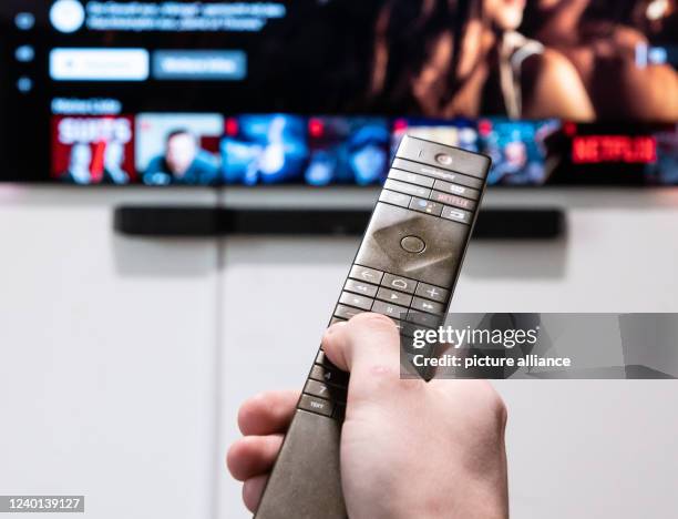 March 2022, Baden-Wuerttemberg, Rottweil: A man holds a remote control in front of his television in his apartment. Photo: Silas Stein/dpa