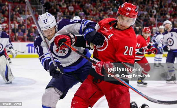 Sebastian Aho of the Carolina Hurricanes and Nikolaj Ehlers of the Winnipeg Jets battle for a loose puck during an NHL game on April 21, 2022 at PNC...