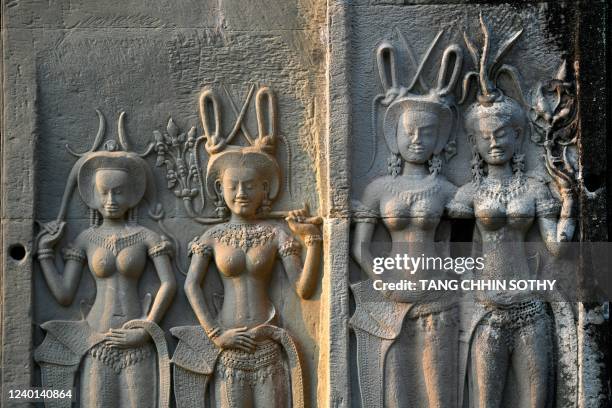 This picture taken on April 8, 2022 shows Apsara bas-reliefs on a wall of the Angkor Wat temple complex, a UNESCO World Heritage Site, in Siem Reap...