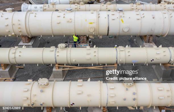 April 2022, Saxony-Anhalt, Leuna: Several distillation columns, the largest with a future height of 60 meters, are being prepared for installation on...