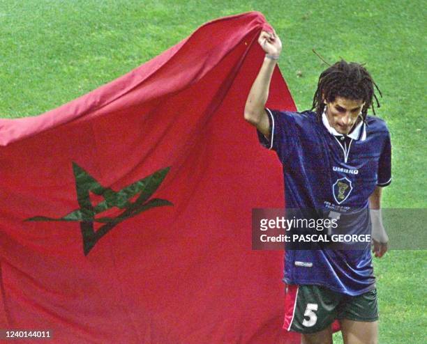 Moroccan midfielder Smahi Triki holds his national flag 23 June at the Stade Geoffroy Guichard in Saint-Etienne, central France, at the end of the...