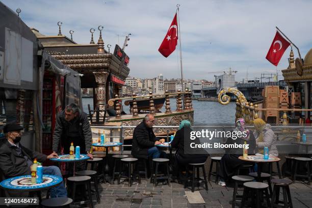 Diners at a terrace outside a port-side cafe in Istanbul, Turkey, on Thursday, April 21, 2022. Turkish inflation soared to a fresh two-decade high in...