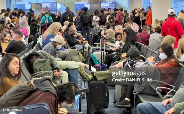 Travelers wait to board a plane at Miami International Airport in Miami, Florida, on April 22, 2022. - The US government is appealing a court ruling...