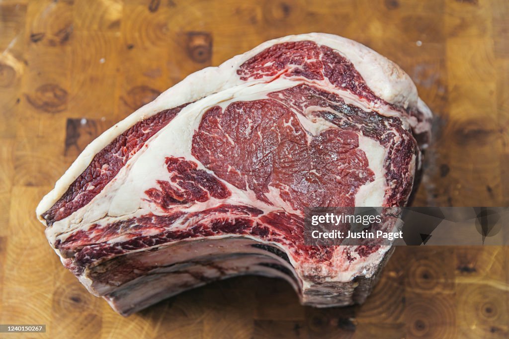 Raw prime rib of beef on a chopping board