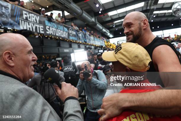 World Boxing Council heavyweight title holder Britain's Tyson Fury is interviewed by his father former boxer John Fury during the weigh-in at the...