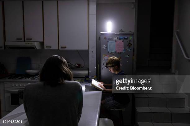 Child reads a book using a head torch after electricity was shut off during a load-shedding power outage in the Hout Bay district of Cape Town, South...