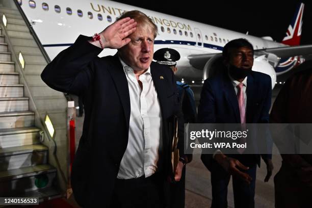 Prime Minister Boris Johnson salutes as he boards his plane for the UK at Delhi airport at the end of his two day trip to India, on April 22, 2022 in...