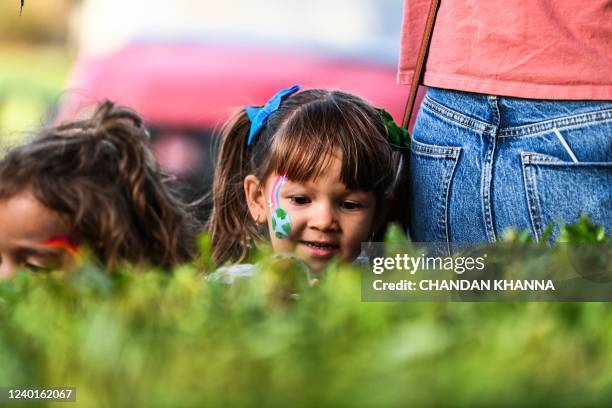 Girl with planet earth painted on her face looks at ladybugs at Doral Glades Park in Doral, Florida on Earth Day, April 22, 2022. - Doral Glades Park...