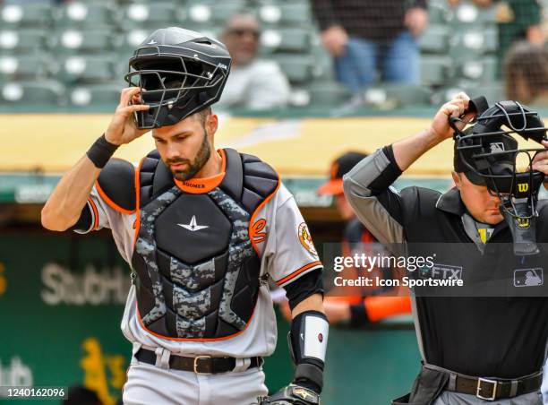 Baltimore Orioles catcher Anthony Bemboom and the home plate umpire return to the plate after chasing down a pop up during the game between the...