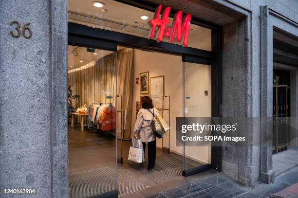 Shopper walks in into the Swedish multinational clothing design retail company Hennes & Mauritz, H&M store in Spain.