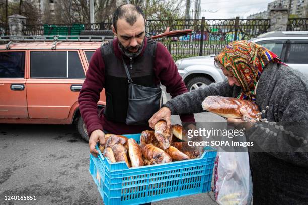 Volunteer distributes bread for the elderly in the northeast of Kharkiv, Ukraine. A bread factory built in Soviet times is now used to cook massive...