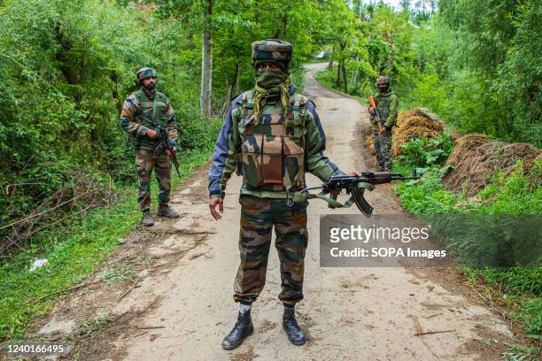 Indian forces stand on guard at a road that leads to the gunfight site in Malwah area of North Kashmir's Baramulla District. Indian forces killed top...
