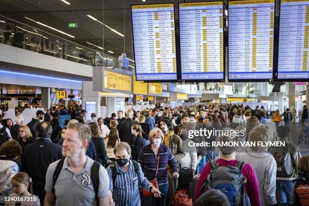 Travellers wait in a departure hall of Schiphol airport during a strike of KLM personnel handling luggages on April 23, 2022. - A wild strike has...