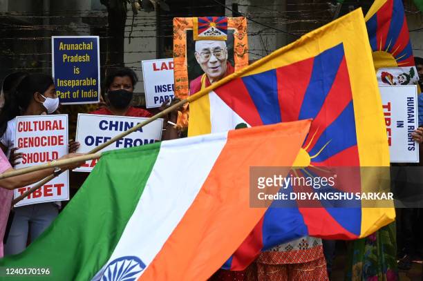 Activists hold a portrait of Tibetan spiritual leader Dalai Lama and wave flags of Tibet and India during a protest against the Chinese invasion in...