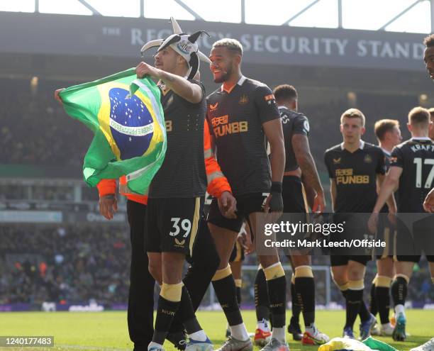 Bruno Guimaraes of Newcastle United celebrates with a Brazilian flag after the scoring the third goal during the Premier League match between Norwich...