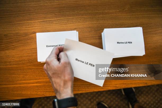 Voter collects name slips as he votes in the second round of the French Elections at the French Consulate in Miami, Florida, on April 23, 2022. -...