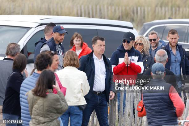 French President and La Republique en Marche party candidate for re-election Emmanuel Macron, next to his wife Brigitte Macron, greets people as he...