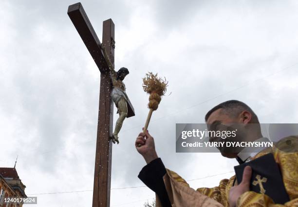 Priest blesses worshippers during a service marking Orthodox Easter outside Saints Peter and Paul Garrison Church, in Lviv, western Ukraine, on April...