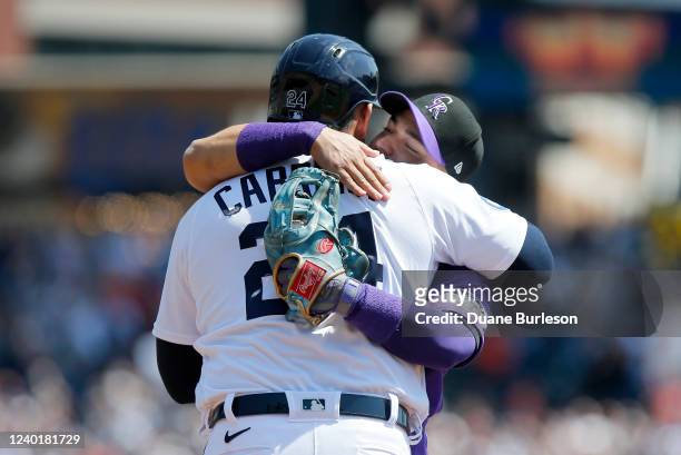 Miguel Cabrera of the Detroit Tigers is hugged by shortstop Jose Iglesias of the Colorado Rockies, with the 3,000th hit baseball in his glove, during...