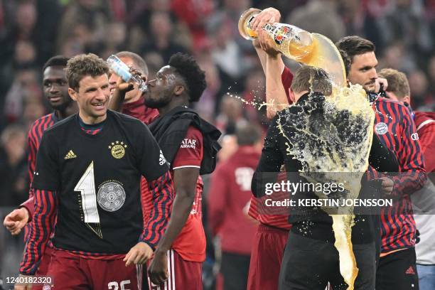 Bayern Munich's German head coach Julian Nagelsmann is soaked with beer as they celebrate after the German first division Bundesliga football match...