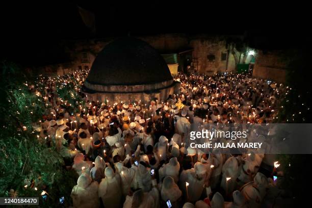 Ethiopian Orthodox Christian pilgrims hold candles during a ceremony of the "Holy Fire" at the Deir Al-Sultan Monastery on the roof of the Holy...