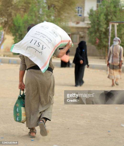 Displaced Yemenis receive food aid donated by a Kuwaiti charitable organisation, on the outskirts of the northeastern city of Marib,on April 23, 2022.