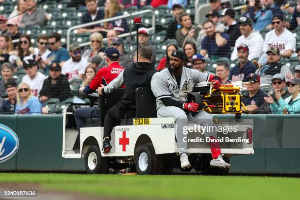 Eloy Jimenez of the Chicago White Sox is carted off the field after getting injured running to first base against the Minnesota Twins in the second...