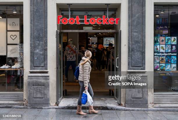 Pedestrian walks past the American multinational sportswear and footwear retailer, Foot Locker store in Spain.