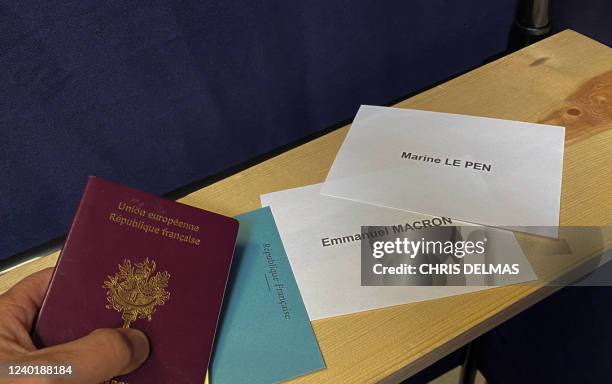 Voting ballots for the two presidential candidates are seen next to a French passport in a voting booth in Burbank, California on April 23, 2022. -...