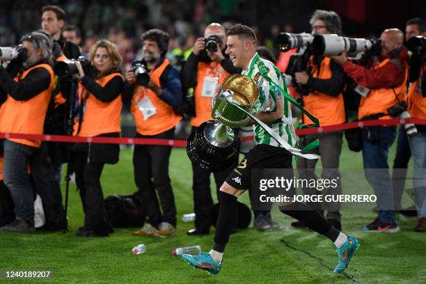 Real Betis' Spanish midfielder Joaquin runs with the winner's trophy after the Spanish Copa del Rey final football match between Real Betis and...