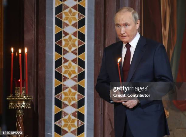 Russian President Vladimir Putin holds a candle during the Orthodox Easter mass led by Russian Orthodox Patriarch Kirill at the Christ The Saviour...