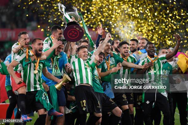 Real Betis' Spanish midfielder Joaquin raises the winner's trophy as he celebrates with teammates their victory after winning the Spanish Copa del...