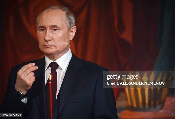 Russian President Vladimir Putin crosses himself during an Orthodox Easter service, late on April 23, 2022 in Moscow.