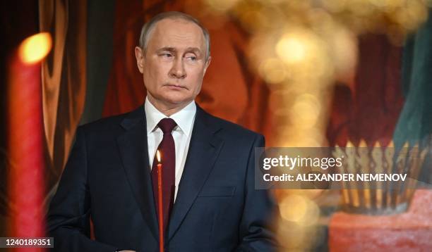 Russian President Vladimir Putin holds a candle during an Orthodox Easter service, late on April 23, 2022 in Moscow.