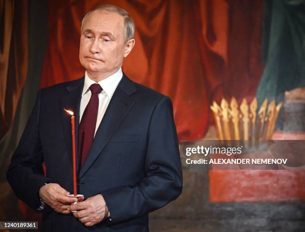 Russian President Vladimir Putin holds a candle during an Orthodox Easter service, late on April 23, 2022 in Moscow.