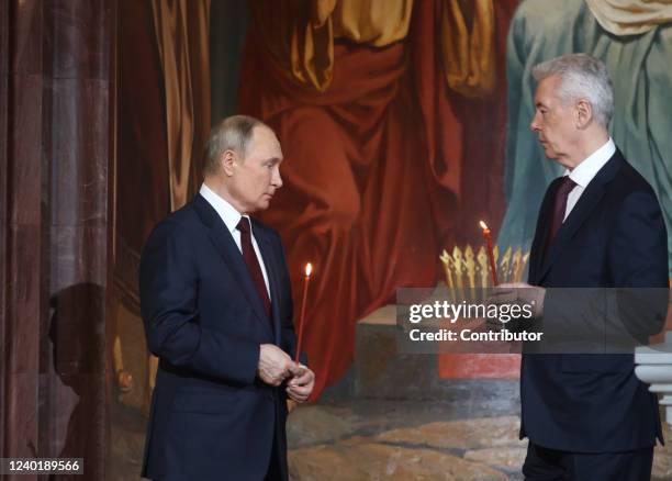 Russian President Vladimir Putin listens to Moscow's Mayor Sergei Sobyanin during the Orthodox Easter mass led by Russian Orthodox Patriarch Kirill...