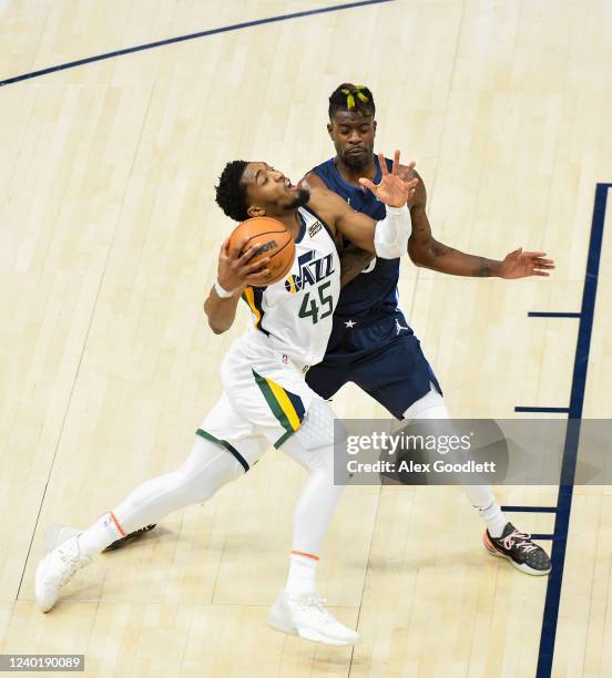 Donovan Mitchell of the Utah Jazz drives into Reggie Bullock of the Dallas Mavericks during the first half of Game Four of the Western Conference...