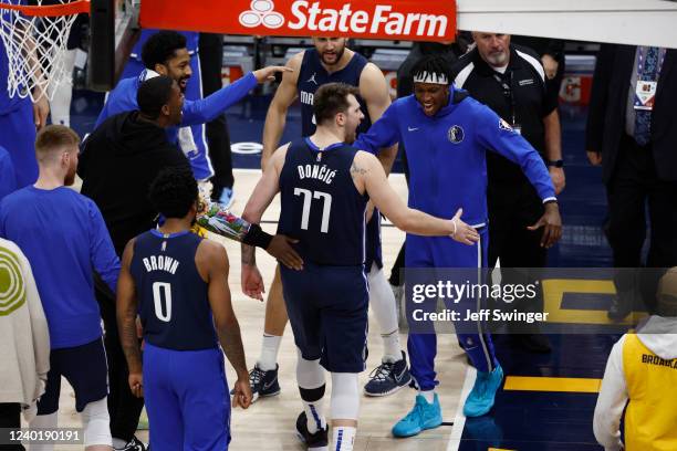 Luka Doncic high fives Frank Ntilikina of the Dallas Mavericks during Round 1 Game 4 of the 2022 NBA Playoffs on April 23, 2022 at Vivint SmartHome...