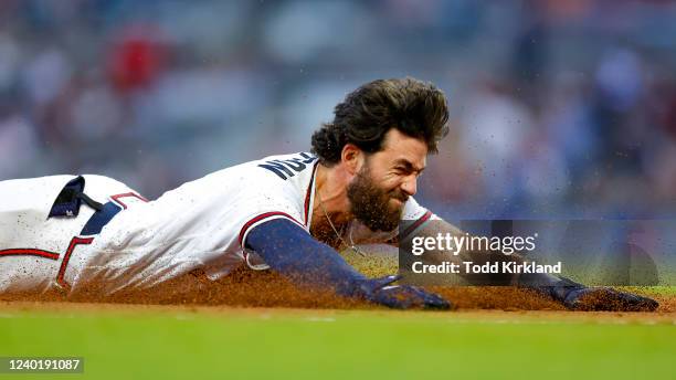 Dansby Swanson of the Atlanta Braves dives into third for a triple during the third inning of an MLB game against the Miami Marlins at Truist Park on...