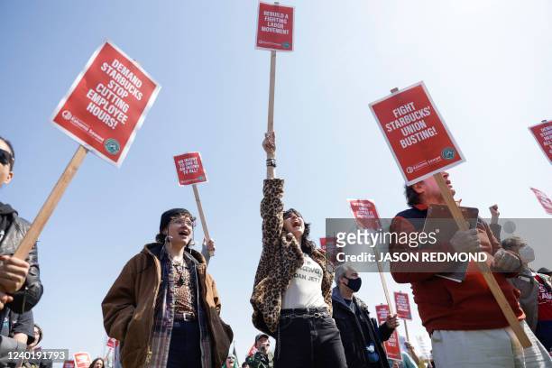 People raise picket signs during the "Fight Starbucks' Union Busting" rally and march in Seattle, Washington on April 23, 2022.