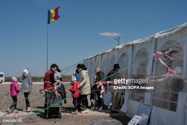 Group of refugees and volunteers seen entering and leaving the refugee reception tent. Near the Palanca border, a refugee reception center with a...